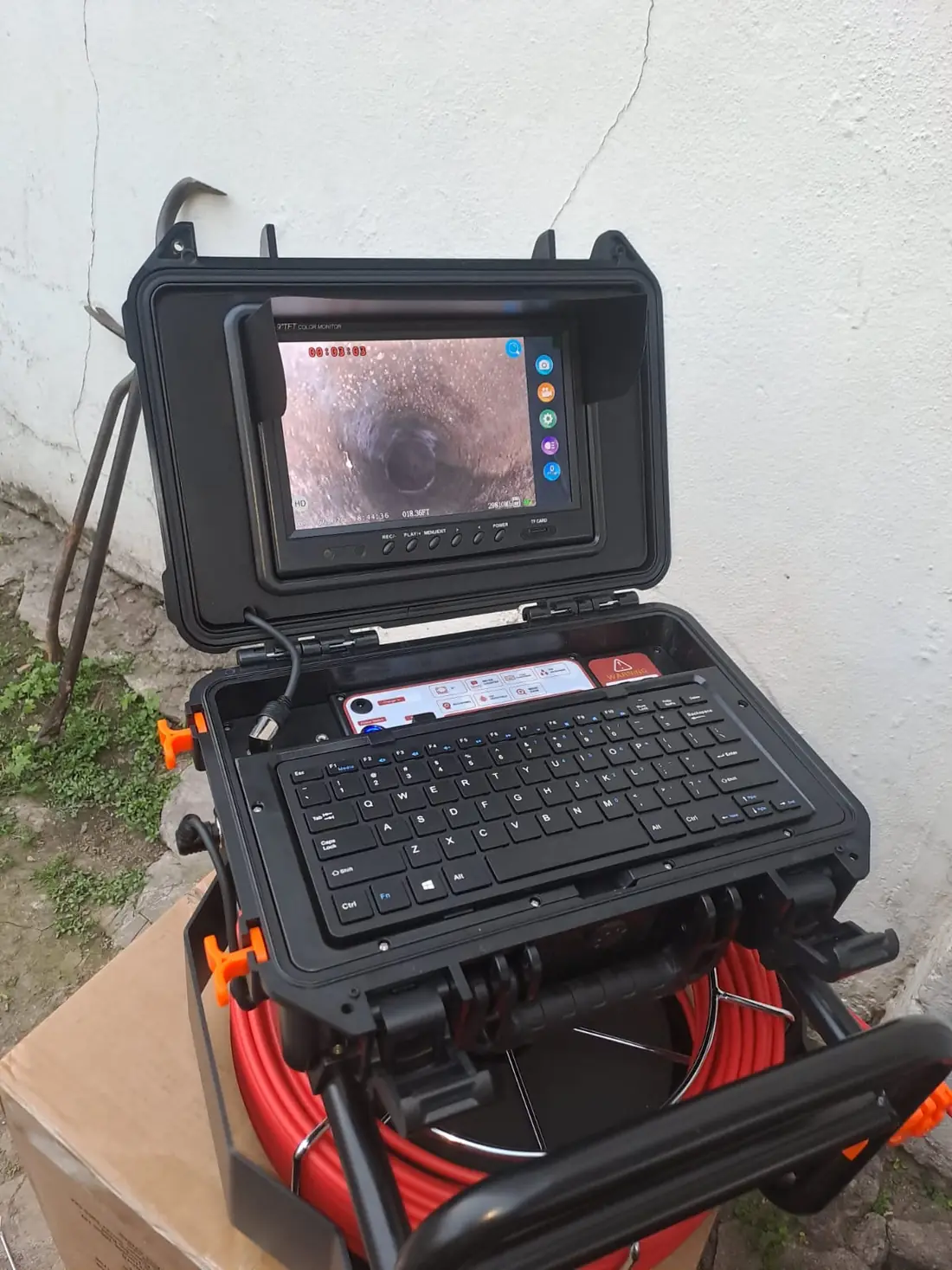 Equipo de video inspección abierto, con la pantalla mostrando el interior de un caño cloacal y el carrete de la sonda